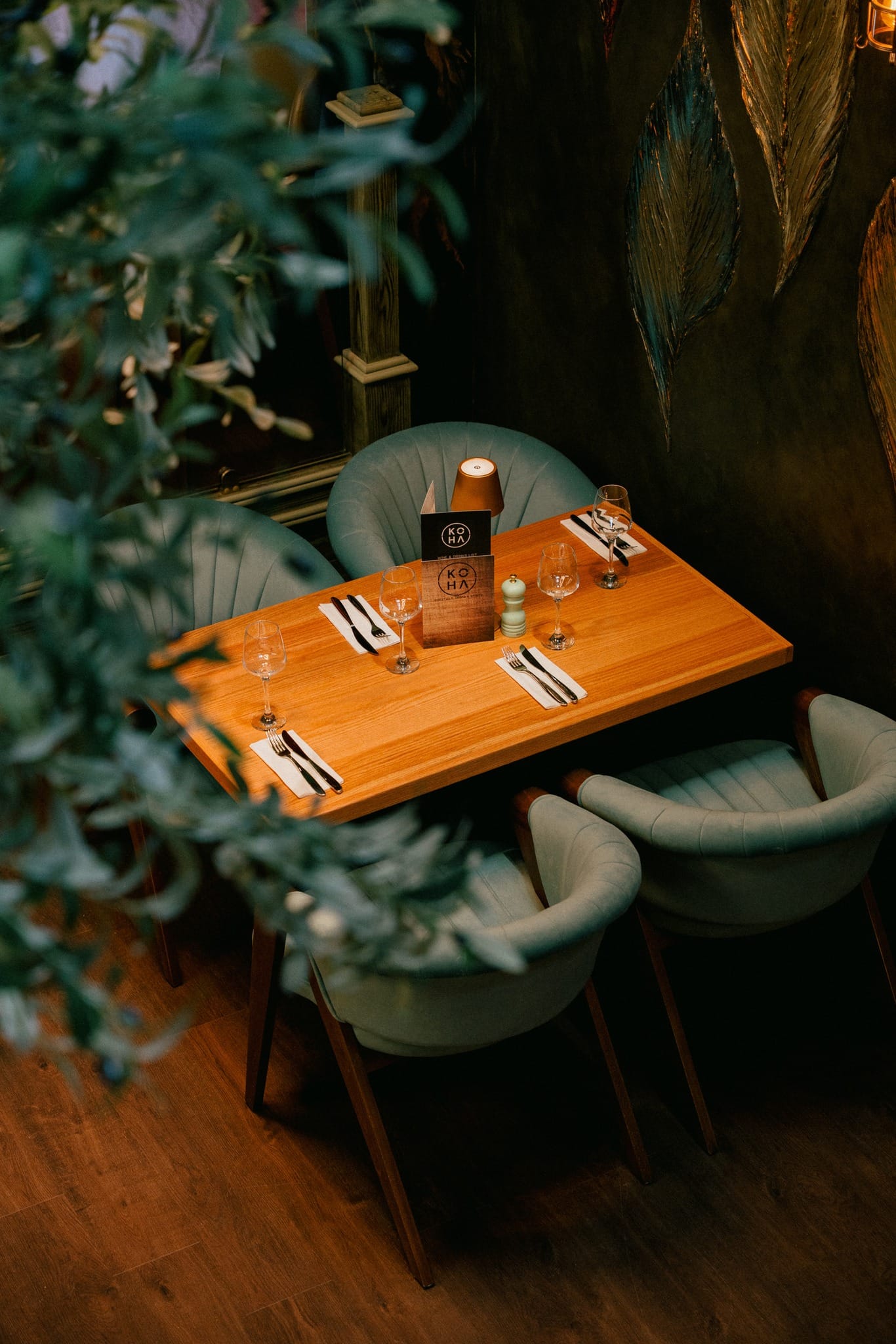 Intimate table setting with teal chairs and olive tree