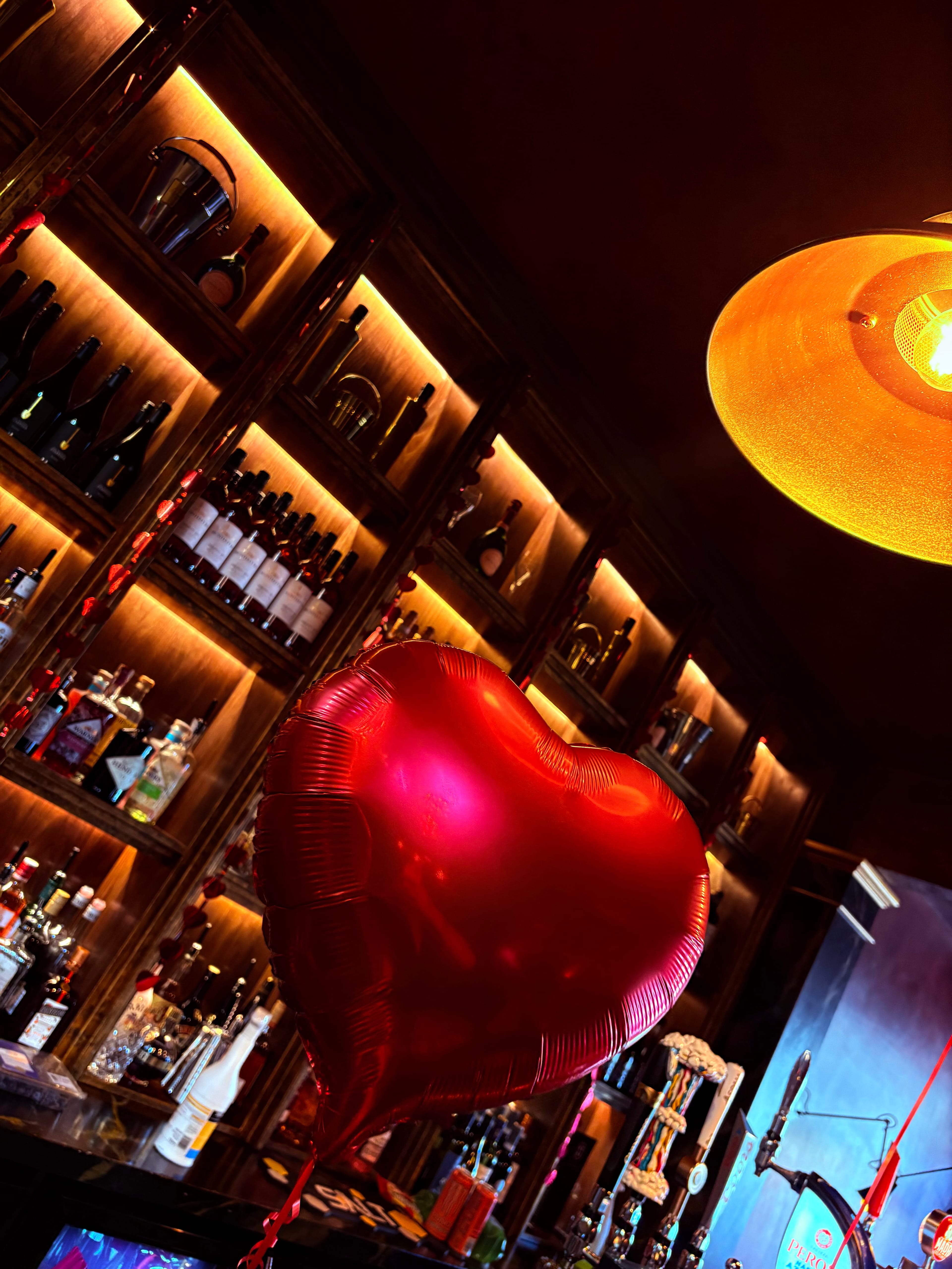 Heart balloon decoration at the bar with backlit shelves