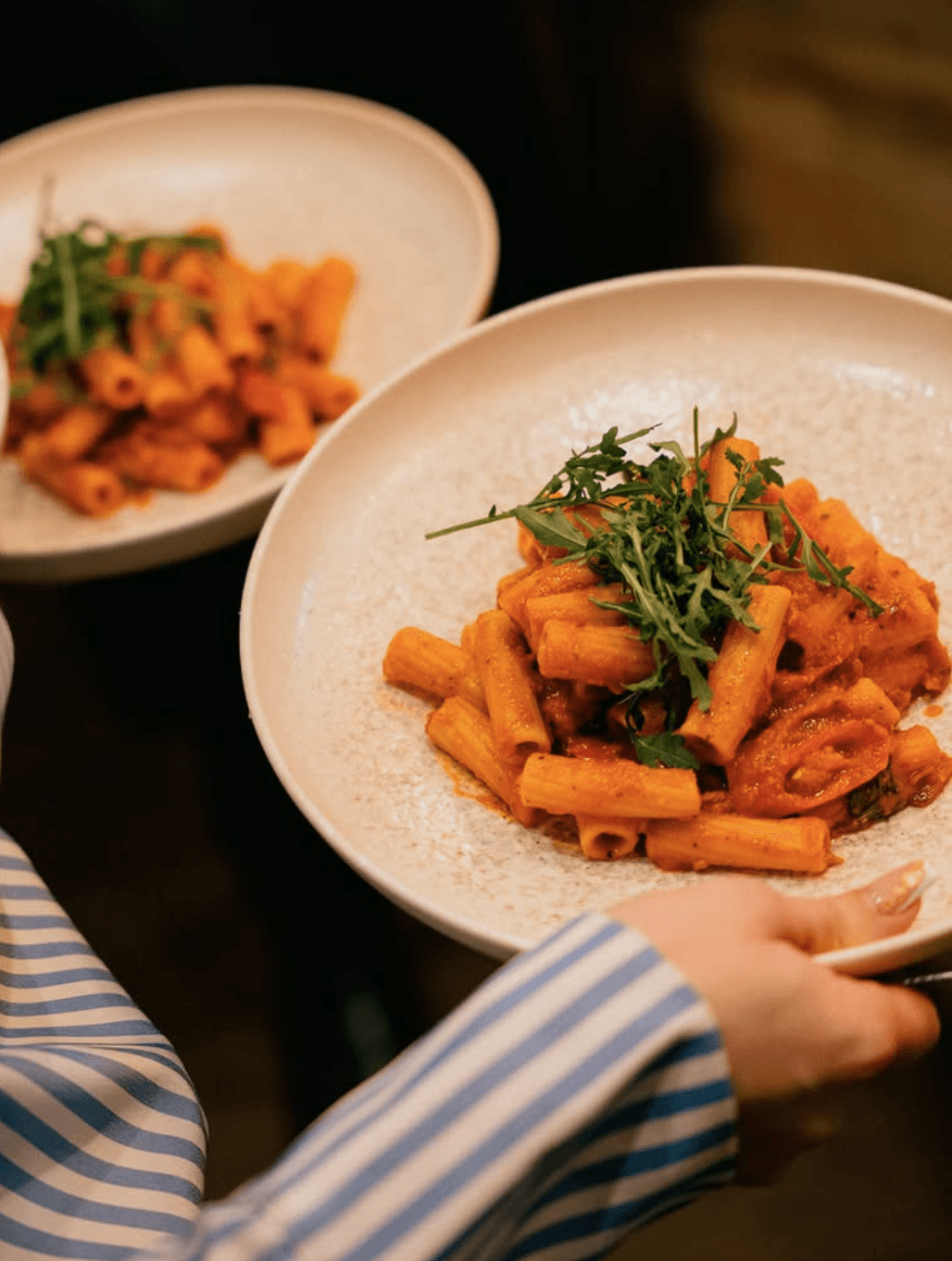 Rigatoni pasta with tomato sauce and fresh arugula